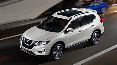 White 2018 Nissan Rogue driving on road